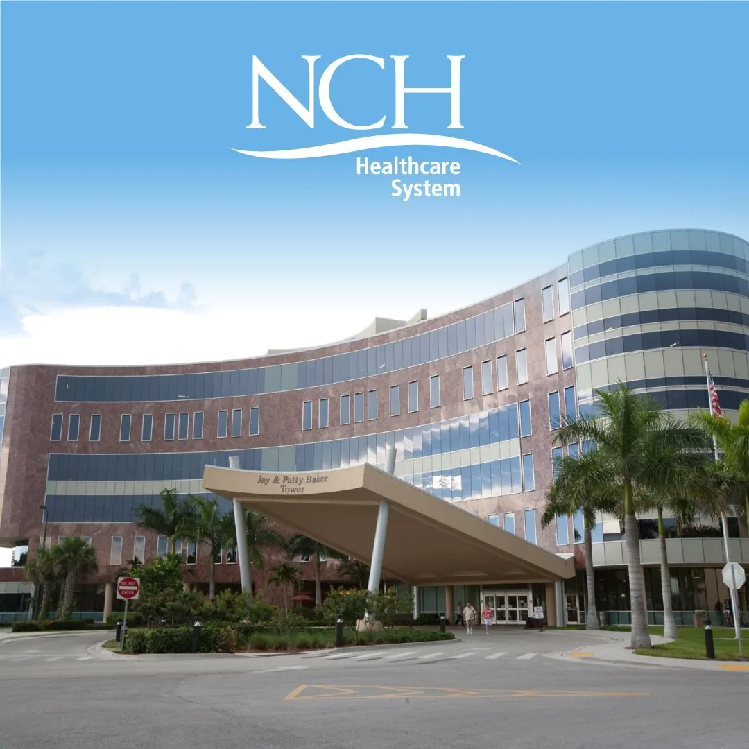The Jay and Patty Baker Tower entrance at NCH North Naples Hospital, framed by palm trees